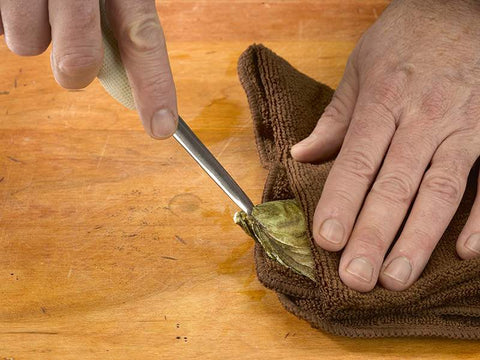 Towel over Oyster on Wooden Surface with Oyster Knife in Hand