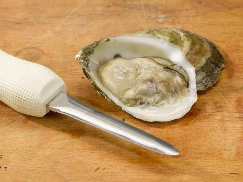 Fresh Shucked Oyster on Wooden Surface with White Oyster Knife