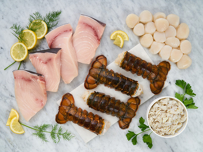 Assortment of Seafood on Marble Surface with Lemons and Herbs