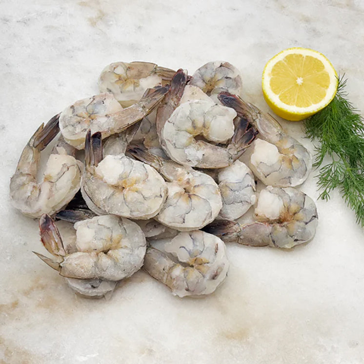 Peeled & Deveined Blue Mexican Shrimp on Marble Surface with Lemon and Herbs
