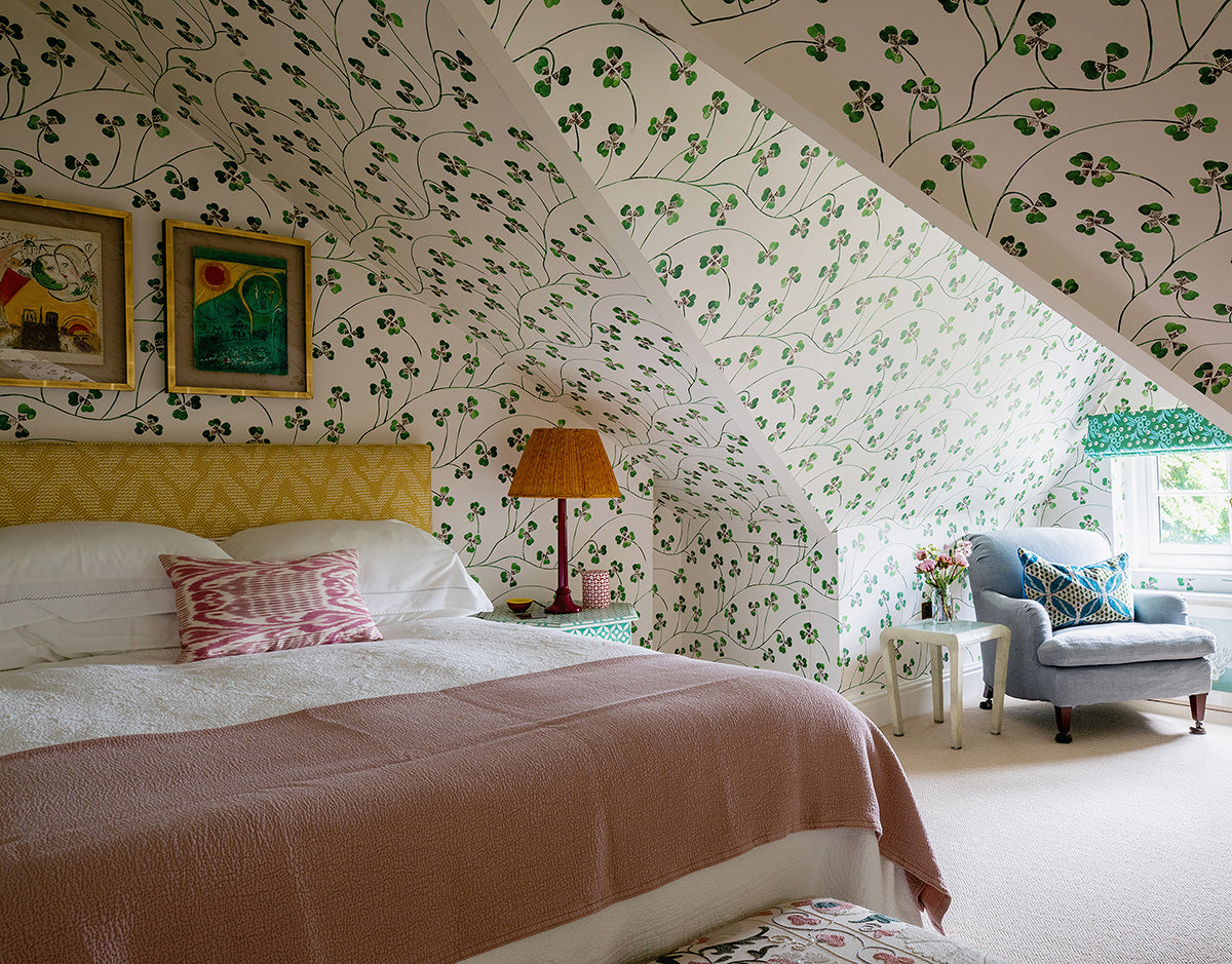 Pink bedroom with Lucky Leaf green clover wallpaper across ceiling