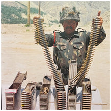Indian Soldier standing with the enemy’s ammunition captured by the Indian Forces.