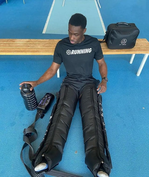 At One Olympic Athlete Omololu recovering after training using the At One Air Compression Recovery Boots