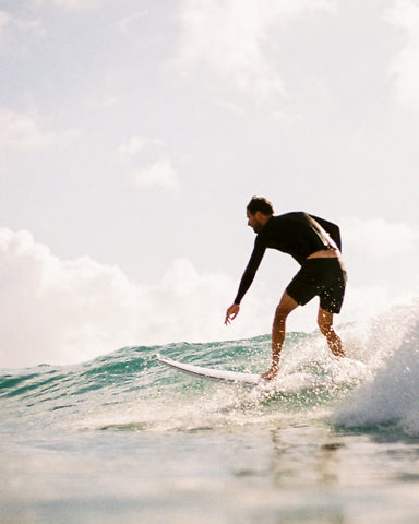 Guy riding a short board surfing a wave