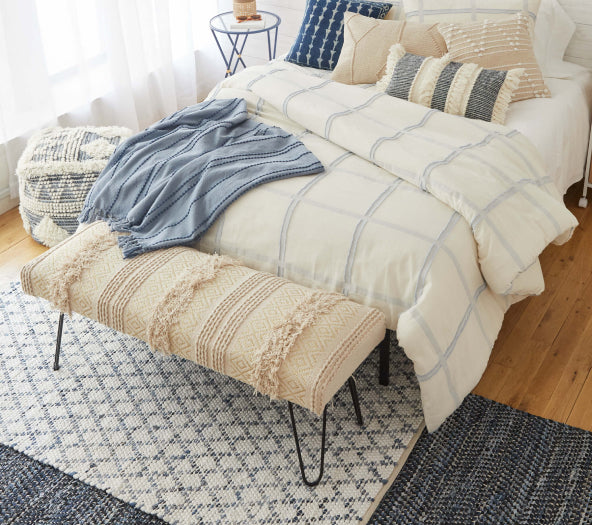Layered woven rugs in bedroom space