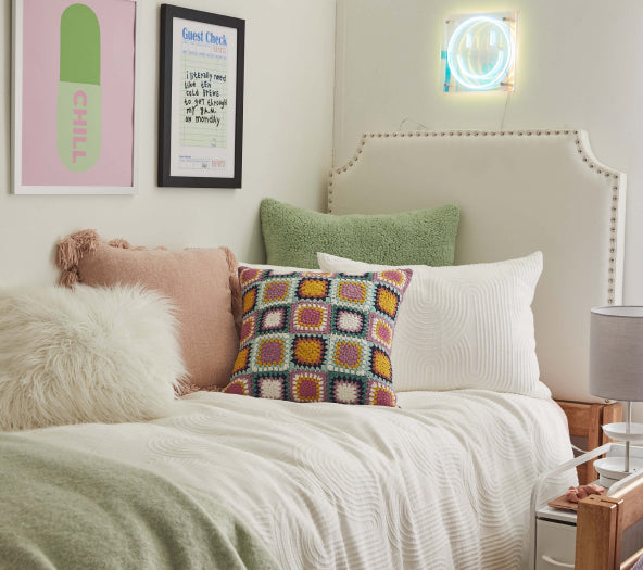 blush pink throw pillow on bed