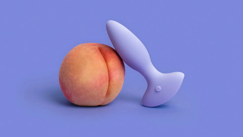 A peach shaped like an ass and a sex toy.