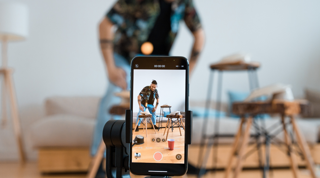 A man recording a short-form video on his cellphone.