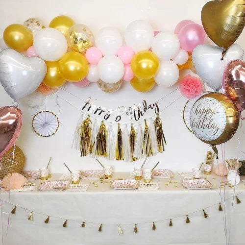 Geburtstagsdekoration in Gold, Rosa und Weiß mit Ballongirlande mit Konfettiballons, Folienballon-Herzen, 'Happy Birthday' Motivballon, 'Happy Birthday' Girland und Tasselgirlande und Partygeschirr
