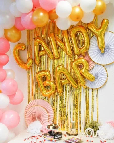 Candybar in Pink, Gold, Weiß mit Ballongirlande, Candybar Ballonschriftzug, Fächern, Pom Poms, Donuts, Mini Dickmans, Schokobons, Kinderriegel