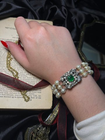 Pearl bracelet worn on the wrist styled with a black velvet cuff