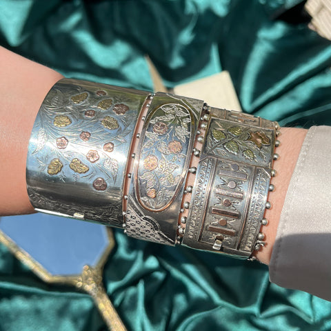 Trio of stacked silver antique cuff bracelets on the wrist