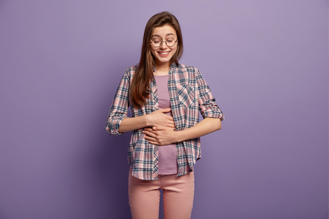 glad-woman-has-full-stomach-after-delicious-dinner-keeps-both-hands-belly-being-well-fed-smiles-positively-dressed-casual-clothes-round-spectacles-isolated-purple-wall-feeling-satiety