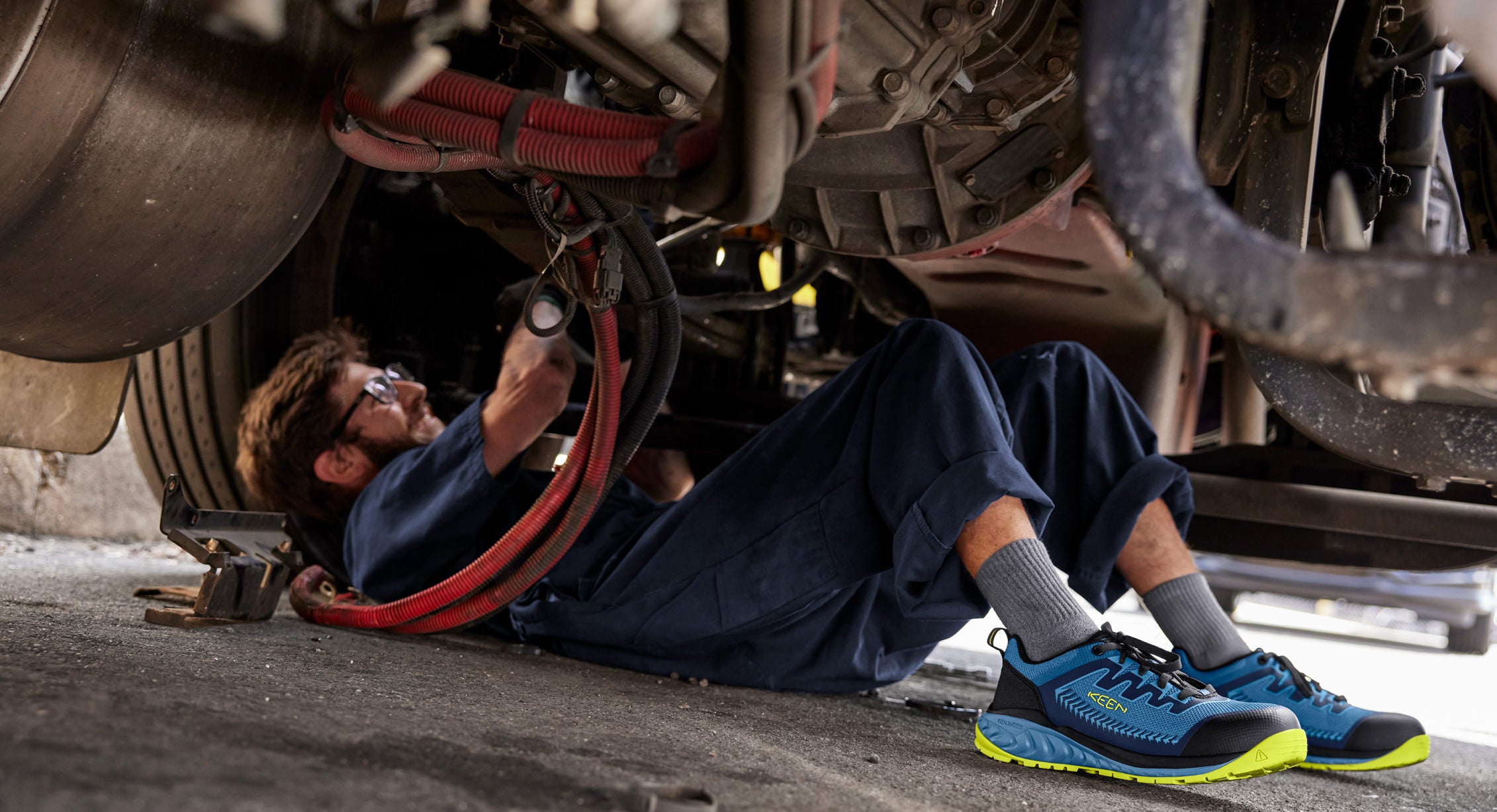 Man working under truck in Arvada work shoes