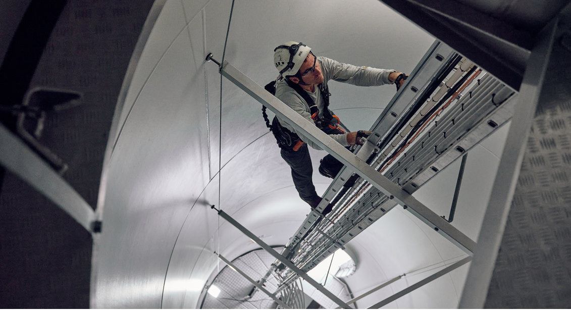 Worker Climbing up the inside of a wind turbine