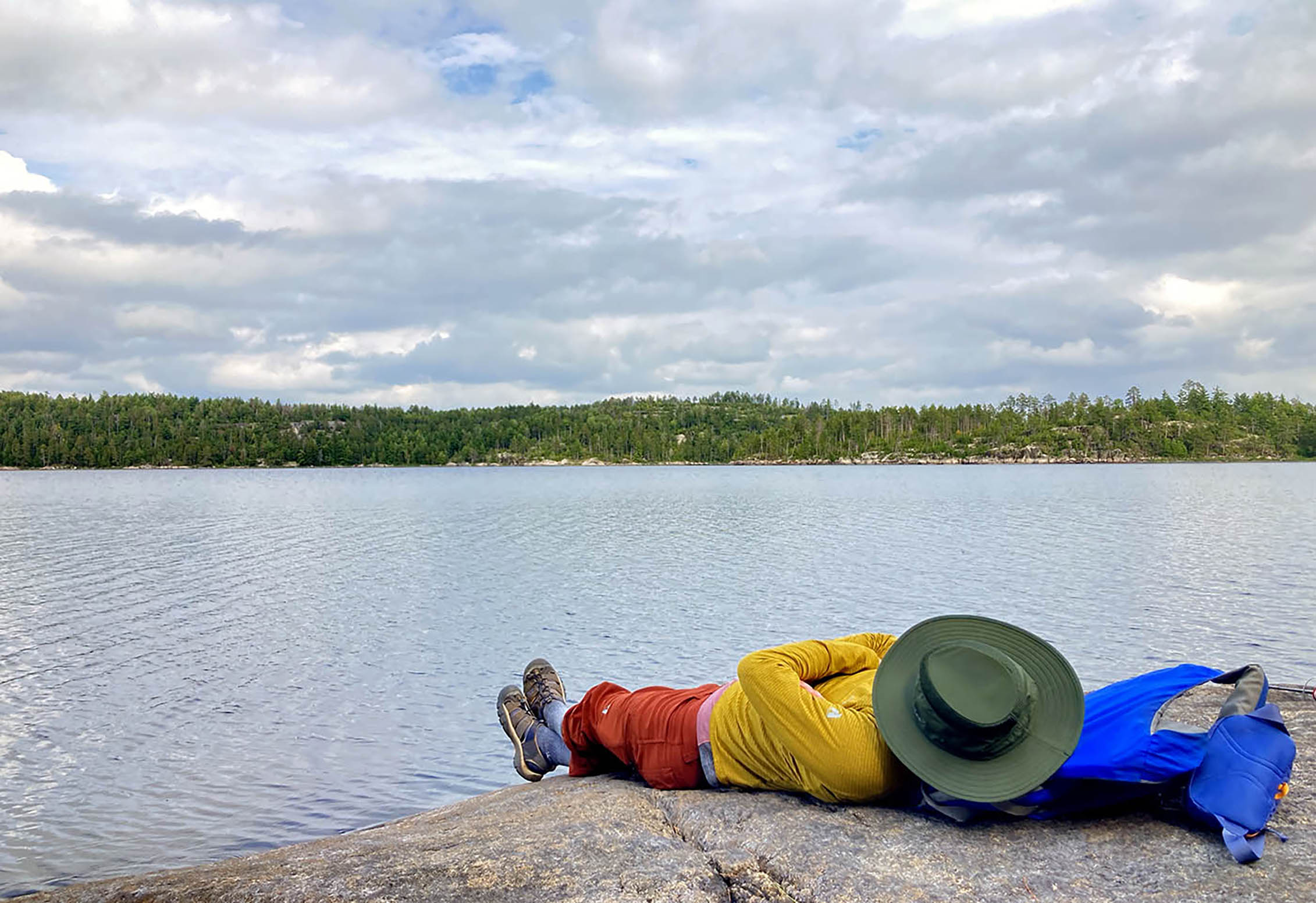 An individual relaxes on a rock in Boundary Waters Wilderness