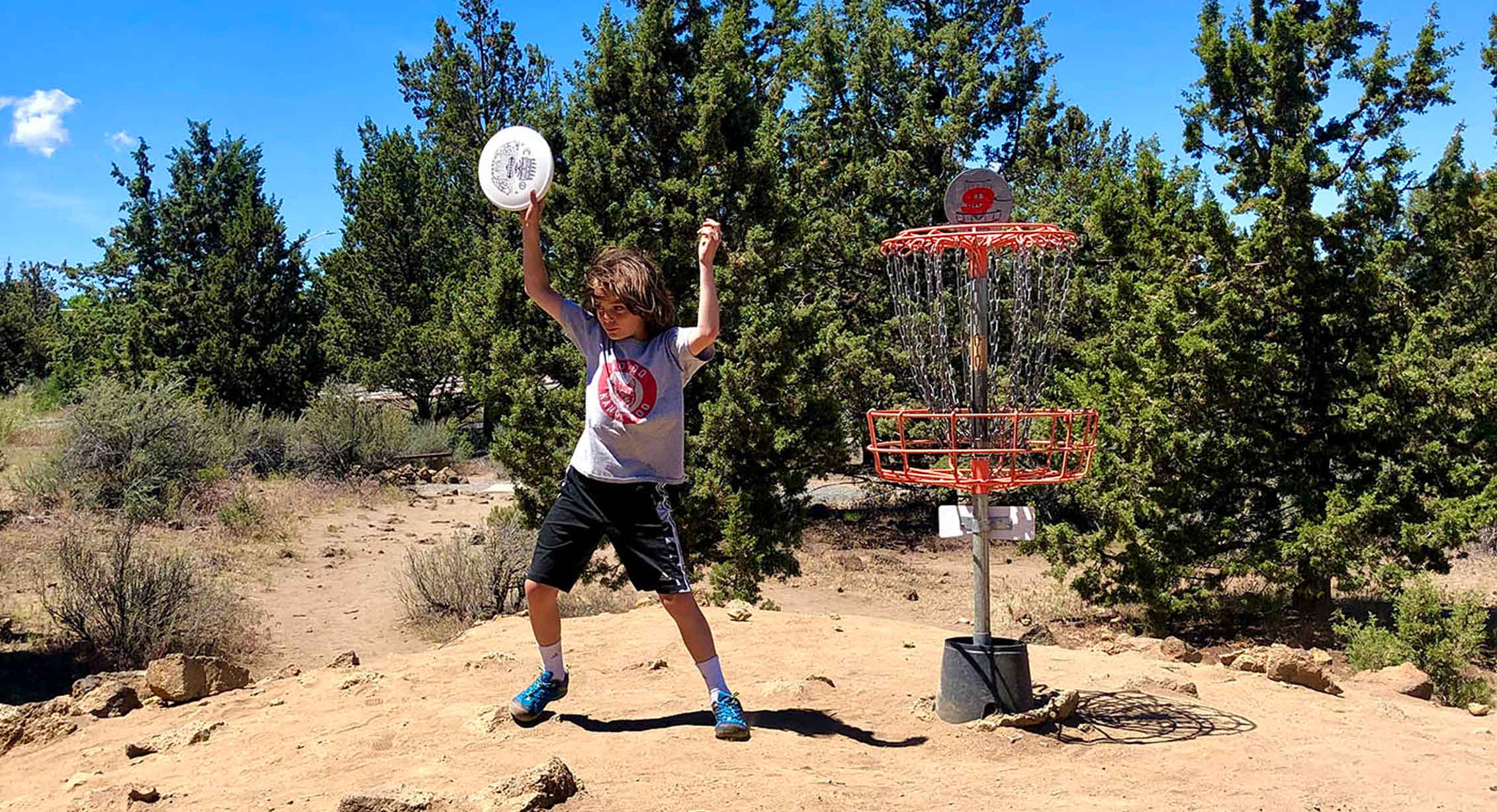 a child dances while playing disc golf