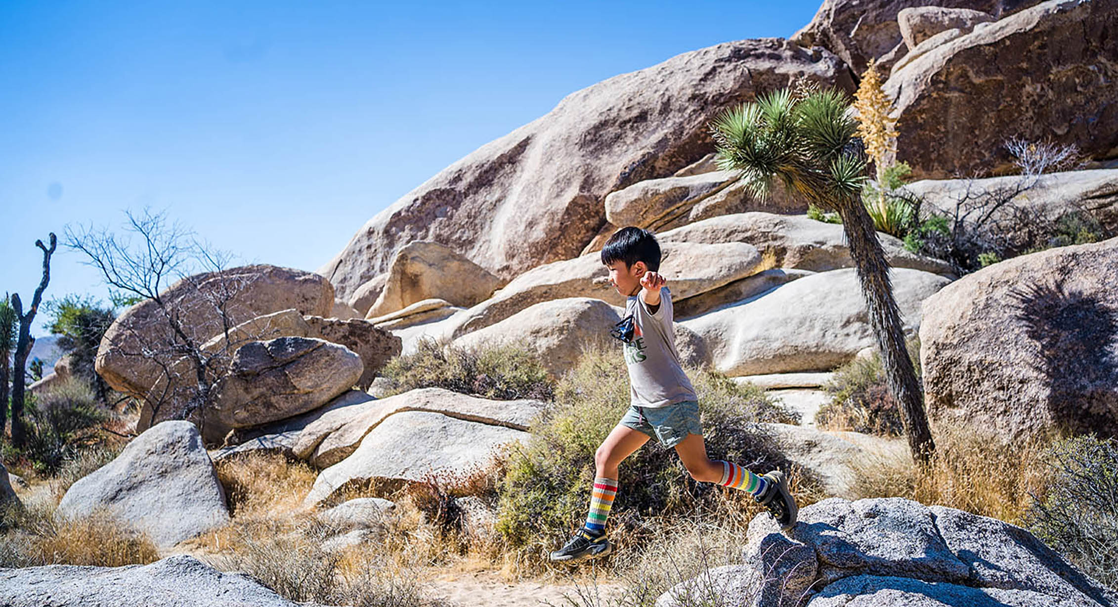 Child exploring boulders in Joshua Tree National Park