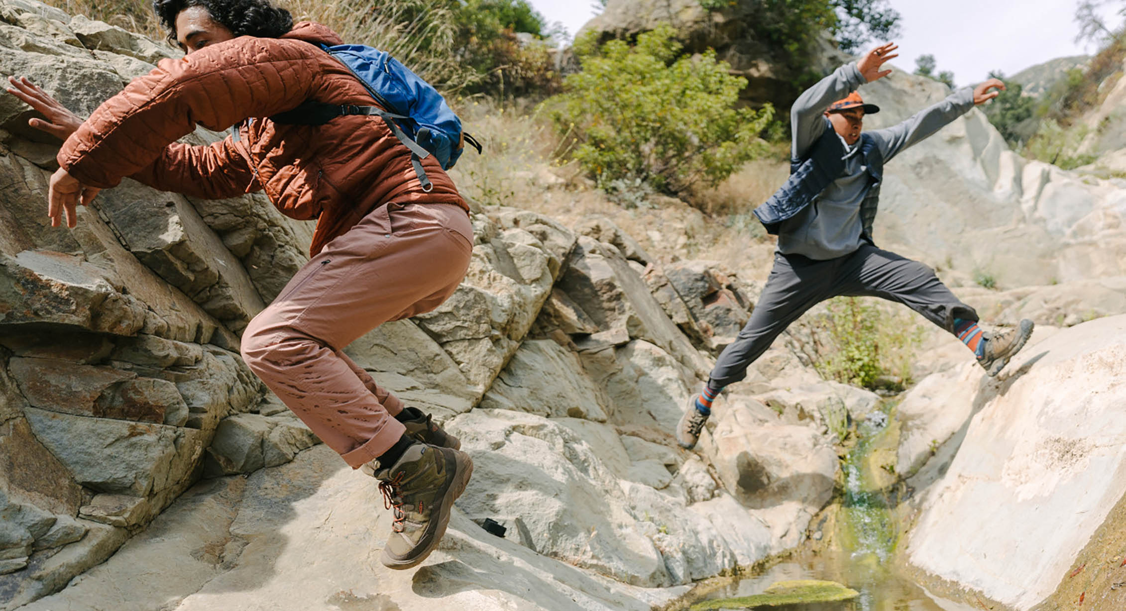 two people parkour their way up a rocky trail