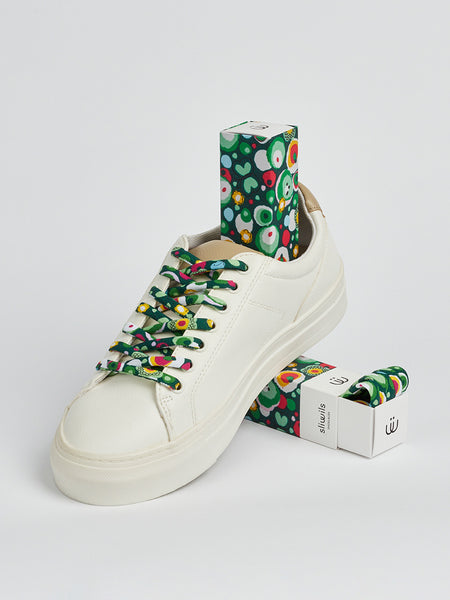 White sneakers with fantasy green print laces