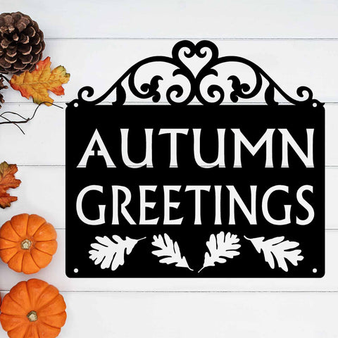 The words Autumn Greetings are cut out of a metal sign with added leaf designs