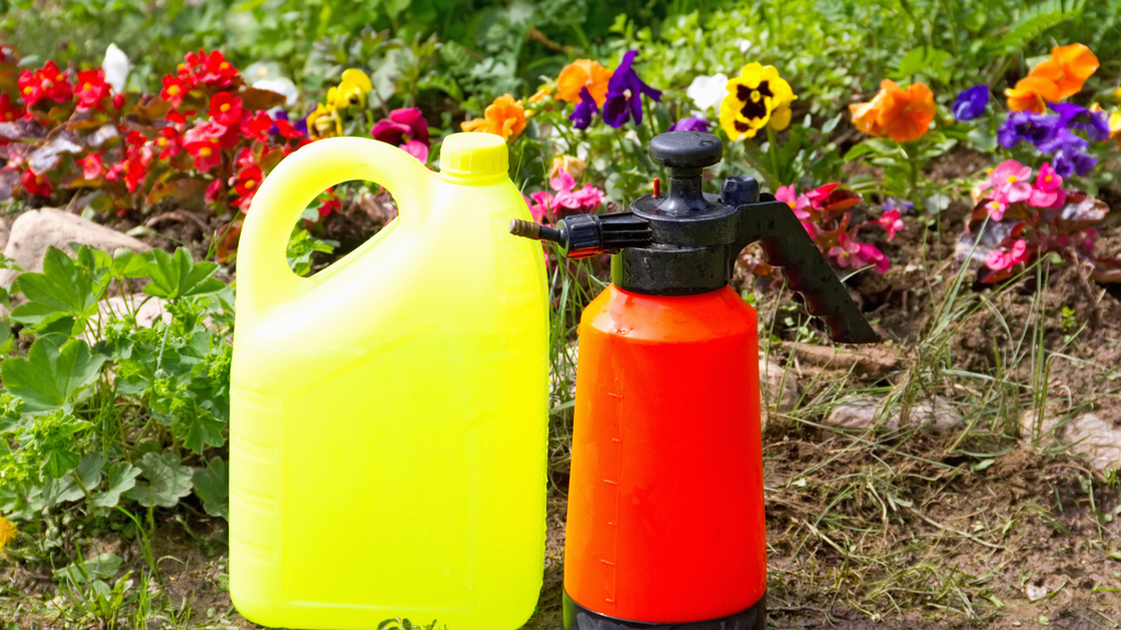 two chemical bottles in front of a garden