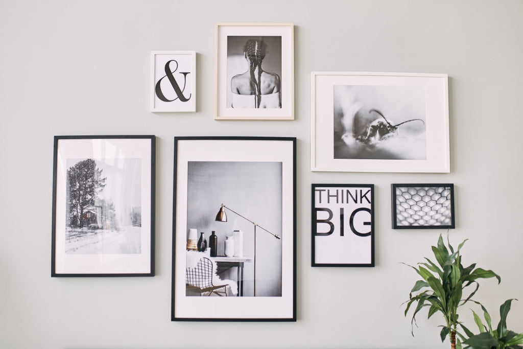 Gallery wall of art on a neutral colored wall.