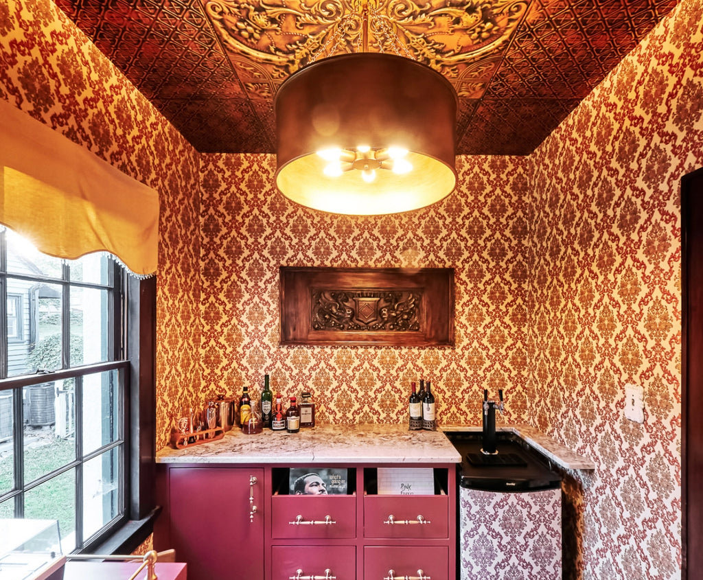 Bar with a blend of patterns in wallpaper and tin ceiling.