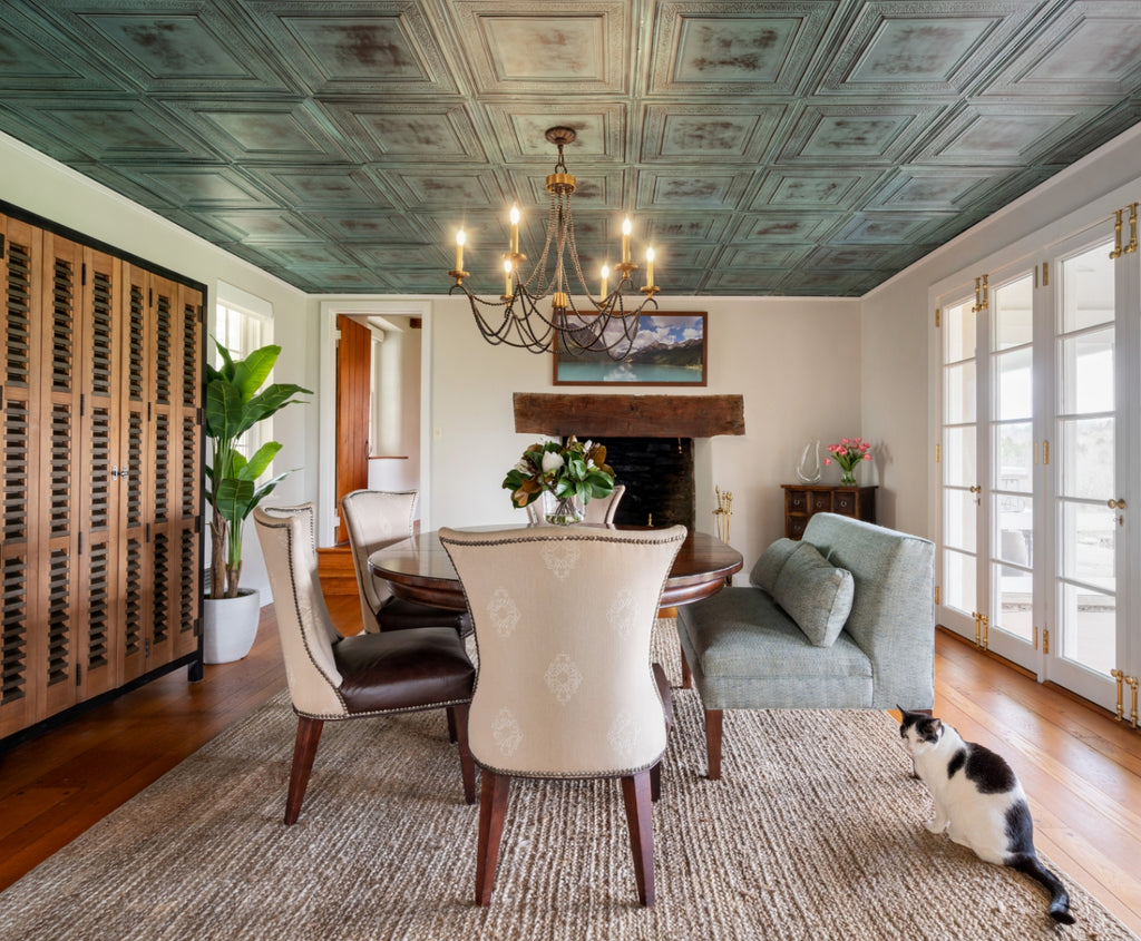 Green tin tile in a dining room with white upholstered dining chairs.