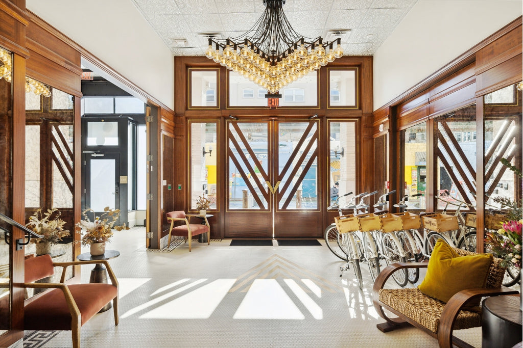 A wide shot of the lobby area featuring a a chandelier on a tin-tile ceiling by American Tin Ceilings.