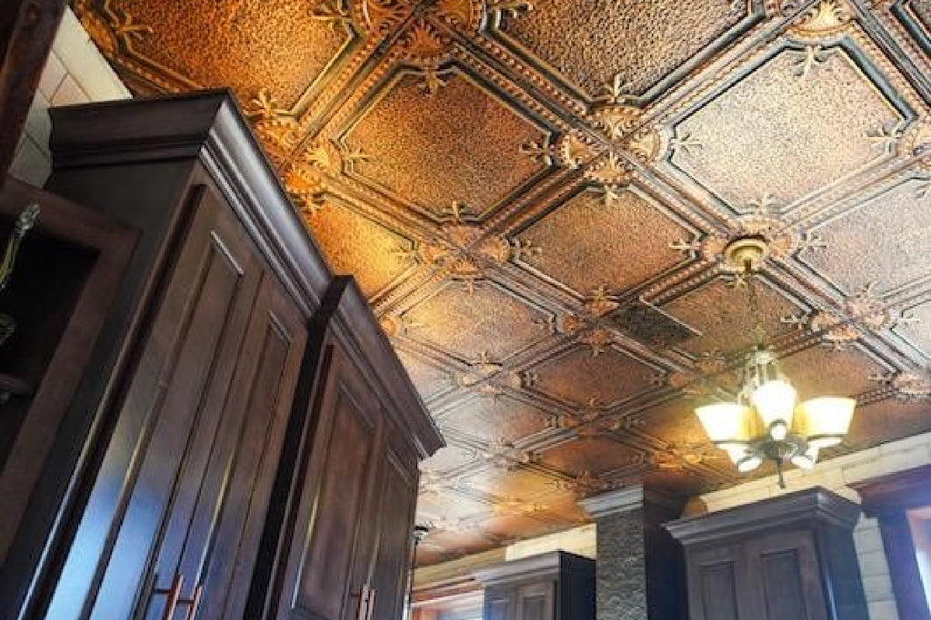 The renovated kitchen, featuring American Tin Ceilings' Pattern 28 in Artisan Copper with Burnt Umber and dark wood cabinets.