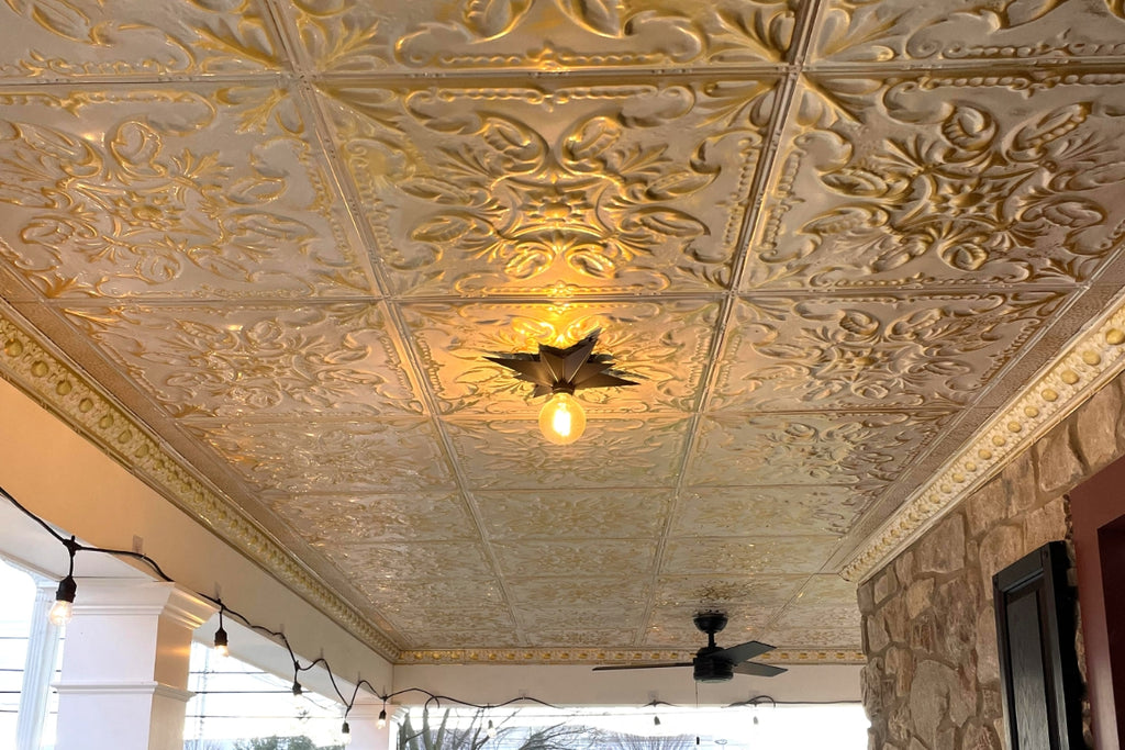 Close up of porch tin ceiling in gold washed with white.