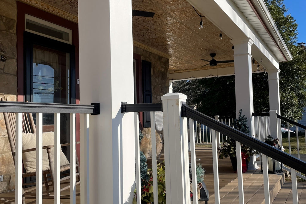 Front porch on a farmhouse style home with gold tin ceiling on the porch ceiling.