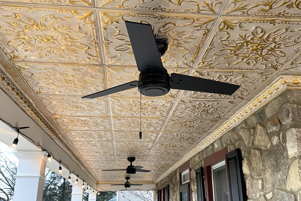 Tin ceiling on the porch with black ceiling fans. 