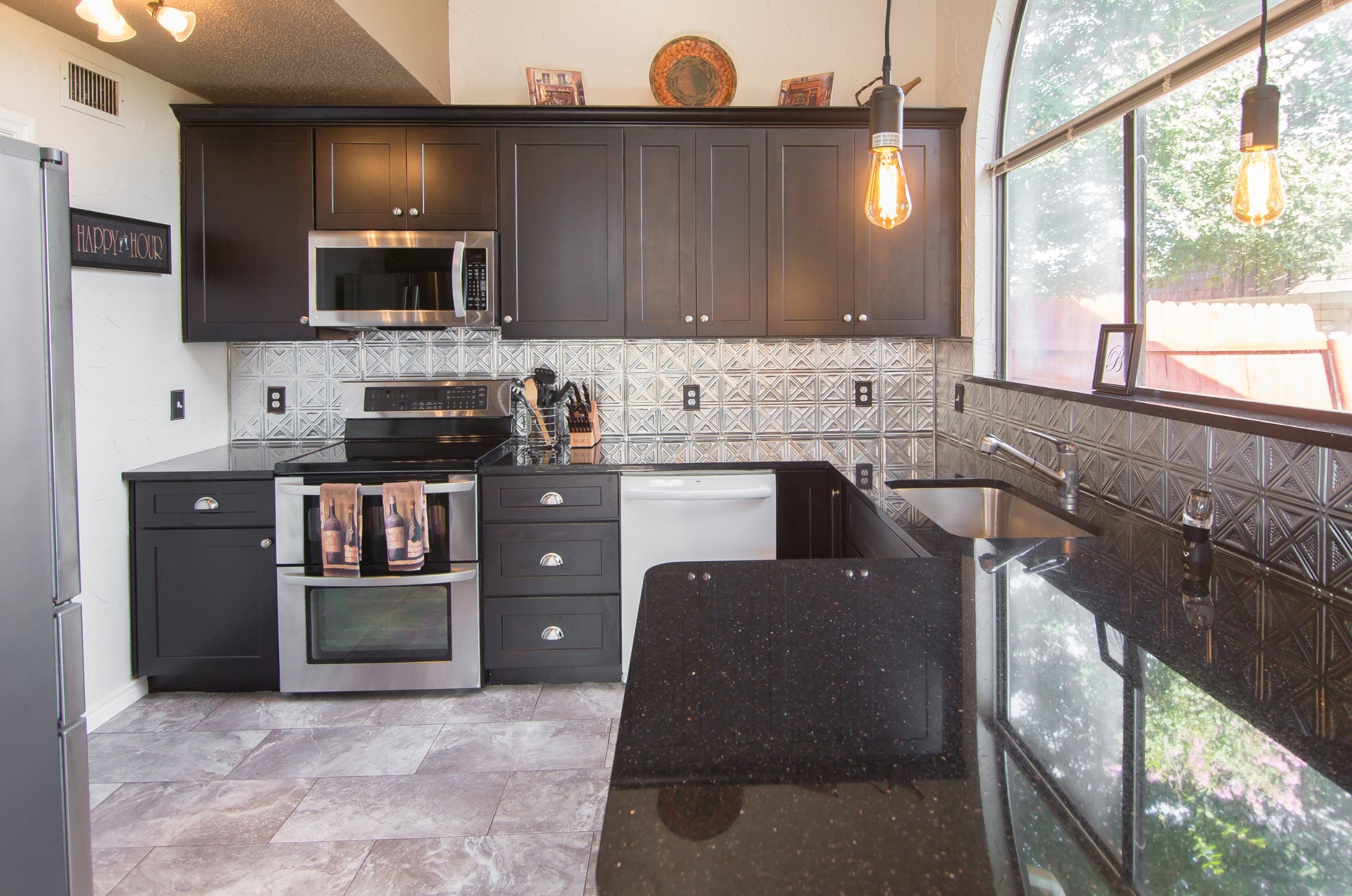 Kitchen in silver and black with tin tile on the backsplash.