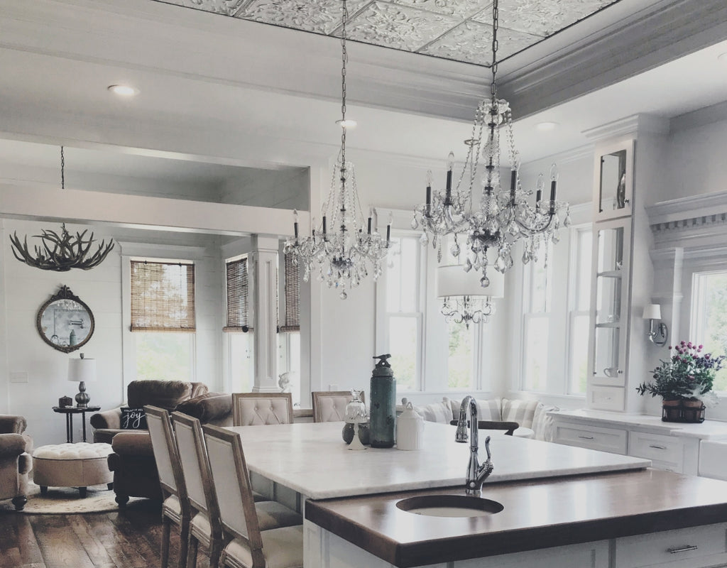 Dining room with crystal chandeliers and silver tin tray ceiling above.