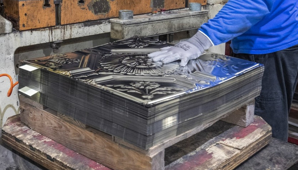 Stack of stamped tin tiles just after they came off the press.