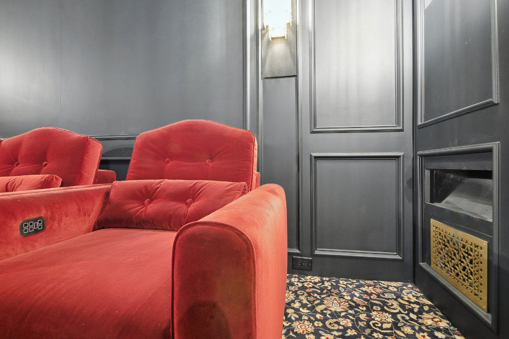 Red velvet recliners in black home theater room.