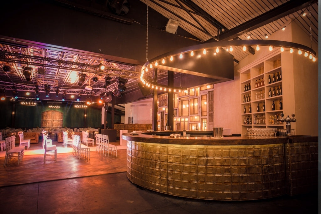 Swanky restaurant space with circular bar and tin tile on the facing of the bar.