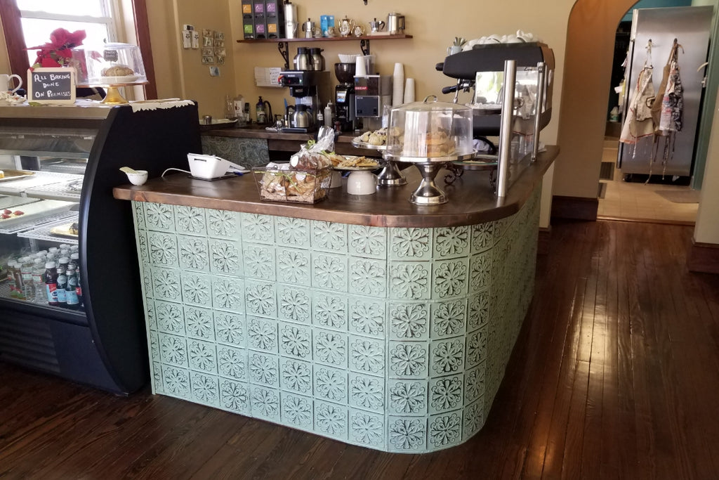 Cafe counter with white tin tile on the front with curved corners.