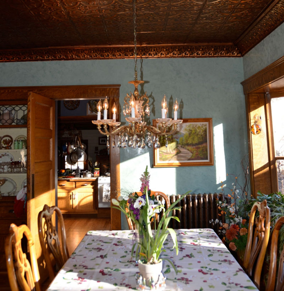 Small dining room with blue walls and tin tile ceiling in copper.