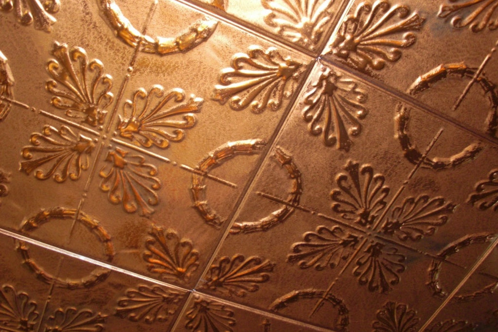 A tessellating pattern in copper tin tile on a ceiling.