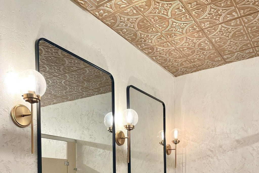 Bathroom with double vanity, sconces, and tin tile on the ceiling.