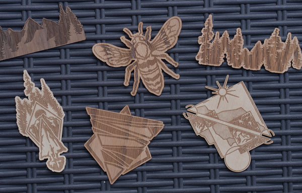 Wooden Stickers in many designs, including logos, mountains, bees and arrowheads, created and laid out.
