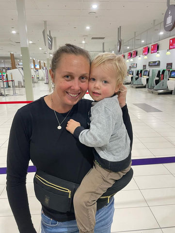 mum at airport using baby carrier - best baby carrier for travel.