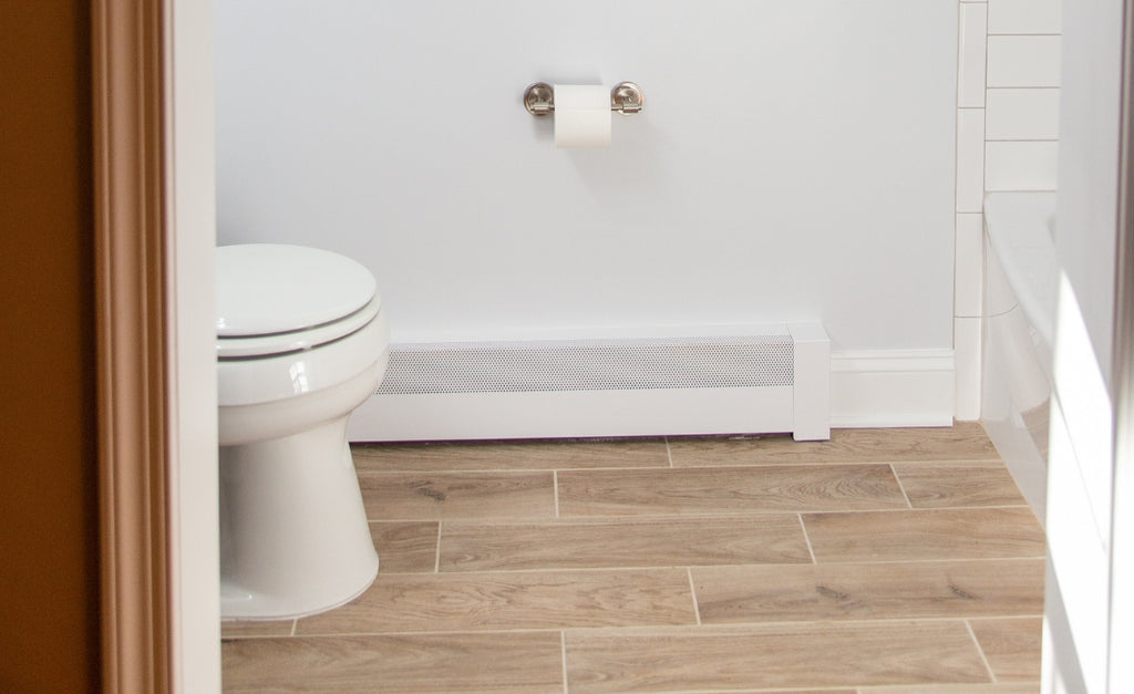 A white Baseboarders heater cover against a white bathroom wall.