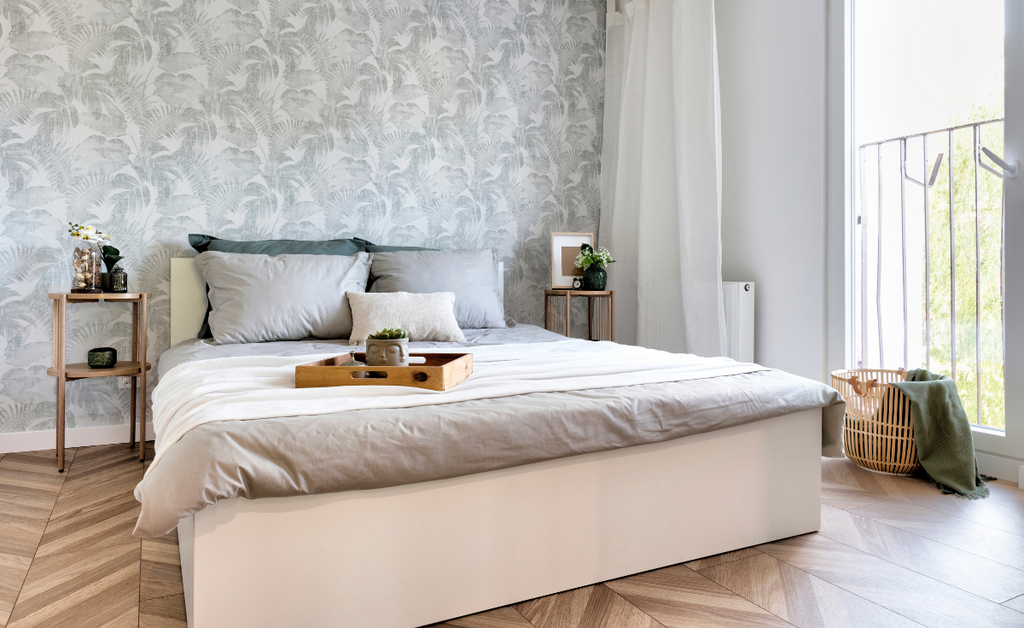 Neutral colored bedroom with chevron wood floor and platform bed.