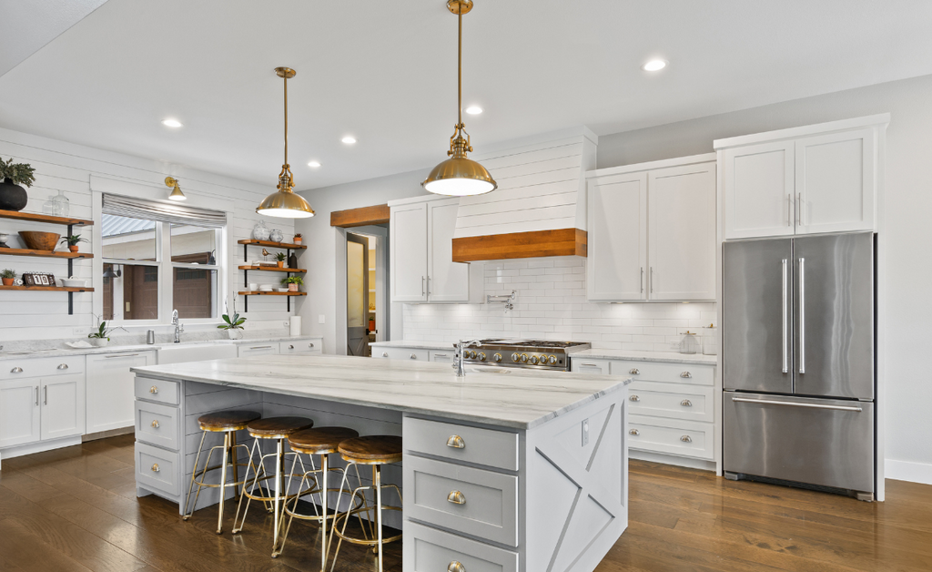 White kitchen with warm wood floors and brass accents.