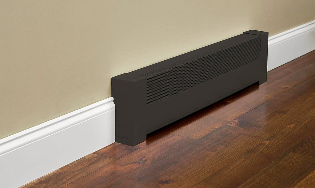 Black baseboard heater cover against a beige wall with with baseboard and dark wood floor.