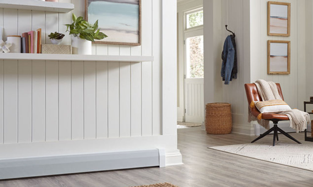 White hydronic baseboard heater in a hallway with bead board.